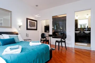 a bedroom with a blue bed and a desk with chairs at Pantheon Amazing Jacuzzi Suite in Rome