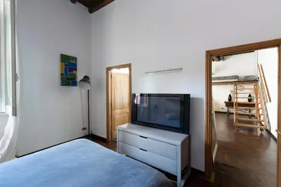 a bedroom with a tv on a dresser and a bed at Rufina Apartment in Rome
