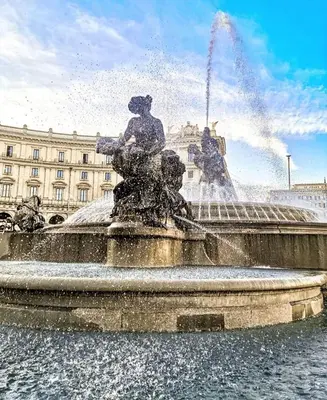 a fountain with two statues in front of a building at Cody's Apartment in Rome
