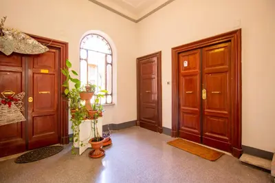 a hallway with two wooden doors and a window at Cody's Apartment in Rome