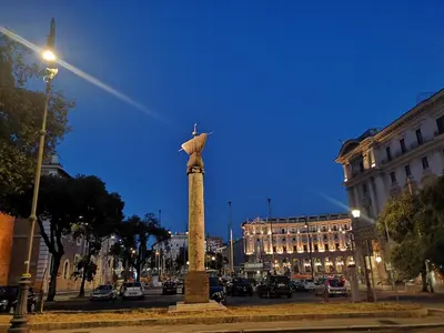 a statue of a bird on a pole in a street at Rome Travellers Hotel in Rome