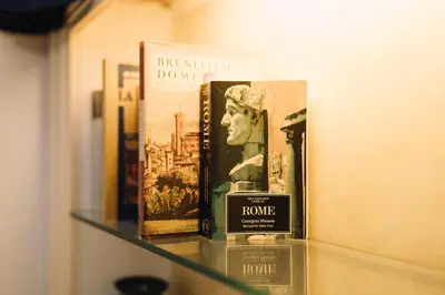 a shelf with books and a bottle of perfume at Limani - Navona Private Apartment in Rome