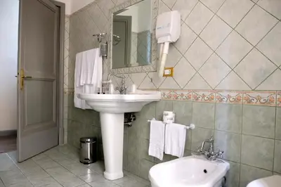 a bathroom with a sink and a toilet and a mirror at Sleep In Rome Ludovisi in Rome