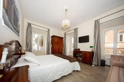 a bedroom with a bed and a desk and a tv at Sleep In Rome Ludovisi in Rome