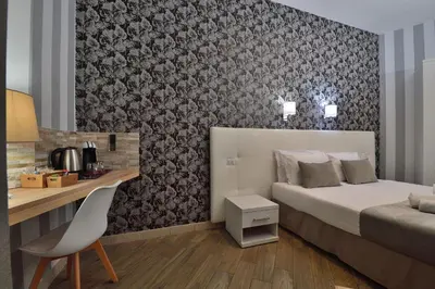a bedroom with a bed and a desk with a chair at Rome Vatican Inn in Rome