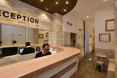 a man sitting at a reception counter in a lobby at Rome Vatican Inn in Rome