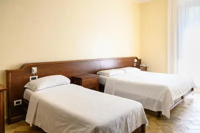 a hotel room with two beds with white sheets at Casa I Cappuccini in Rome