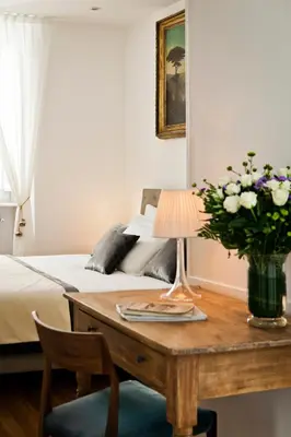 a bedroom with a bed and a table with a vase of flowers at Garibaldi Suites Piazza Di Spagna in Rome