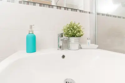 a blue bottle sitting on a sink in a bathroom at Bye Bye Roma Pantheon Suite in Rome