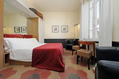 a bedroom with a bed and a desk and a piano at Michelangelo Charmsuite in Rome