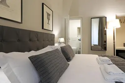 a bedroom with a large white bed and a mirror at RESIDENZA VITTORIA Roma in Rome