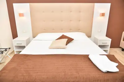 a bedroom with a large white bed with a large headboard at Your Rhome in Rome