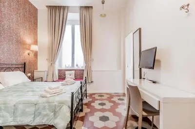 a bedroom with a bed and a desk and a television at B&B Trastevere 94 in Rome
