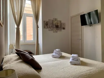 a bedroom with a bed with towels on it at Guest House Casa Vicenza in Rome
