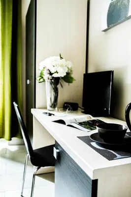 a desk with a vase of white flowers on it at Mosaic Central Guest House in Rome