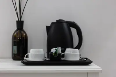 a black tea kettle and two cups on a counter at Hotel Max in Rome