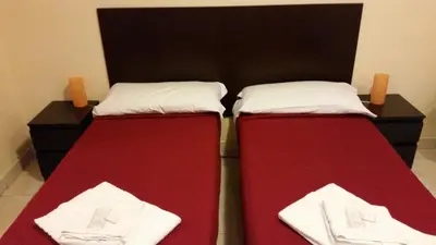two beds in a room with red and white sheets at Hostel Mosaic in Rome