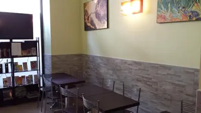 a dining room with two tables and chairs and a tv at Hostel Mosaic in Rome