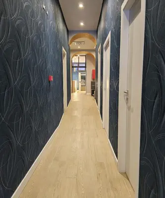 a hallway with black walls and a long hallway with wood floors at Hotel Mosaic Central Rome in Rome