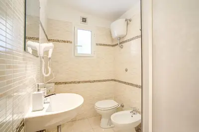 a white bathroom with a sink and a toilet at Hotel Mosaic Central Rome in Rome