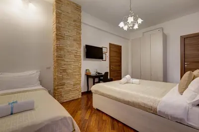 a hotel room with two beds and a tv at Little Rhome Suites in Rome