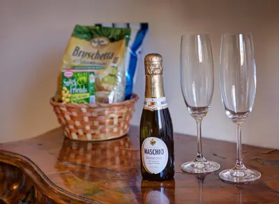 a bottle of champagne and two wine glasses on a table at Little Rhome Suites in Rome