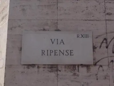 a sign on the side of a wall with graffiti at Little Rhome Suites in Rome