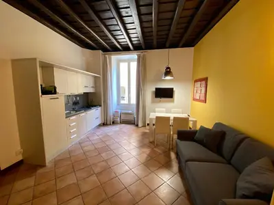 a living room with a couch and a table and a kitchen at SWEETSUITE Rome in Rome