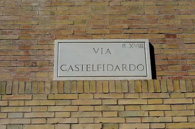 a sign on the side of a brick wall at Aquarius Inn in Rome