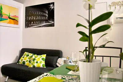 a living room with a black couch and a table with a plant at Nostromondo Apartments in Rome City Centre in Rome