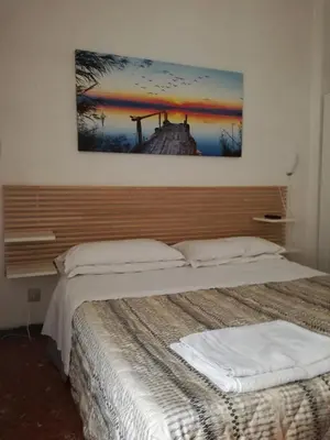 a bedroom with two beds and a painting on the wall at Testa Gioacchino B&B in Rome