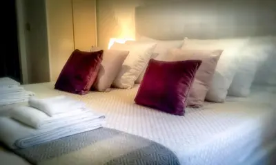 a bed with white pillows and purple and white pillows at Casina Tiberina in Rome