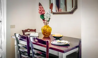 a dining room table with a yellow vase with flowers at Casina Tiberina in Rome