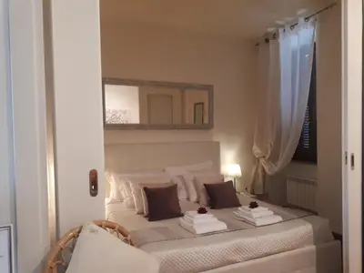a bedroom with a white bed with a mirror at Casina Tiberina in Rome