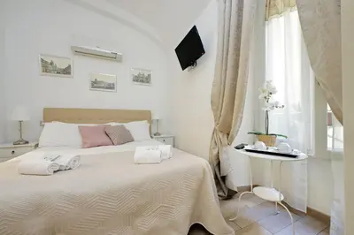 a white bedroom with a bed with two towels on it at Dream City Rome in Rome