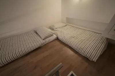 two beds in a small room with wooden floors at San Lorenzo 42 in Rome