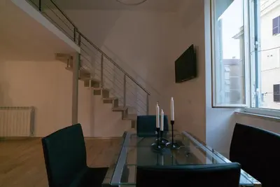 a dining room with a glass table and a staircase at San Lorenzo 42 in Rome