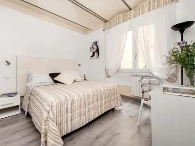 a white bedroom with a bed and a window at White Rooms Colosseo in Rome
