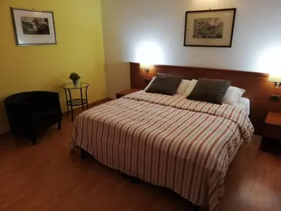 a bedroom with a bed with a striped blanket and a chair at Domus Appia 154 B&B in Rome
