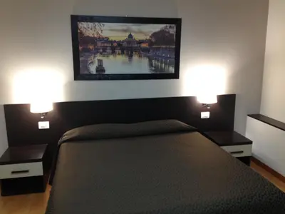 a bedroom with a bed with two lights on it at Domus Appia 154 B&B in Rome
