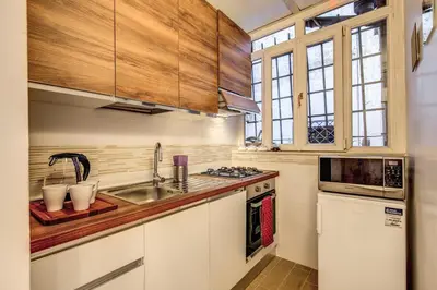 a kitchen with wooden cabinets and a sink at Casa Monticelli in Rome