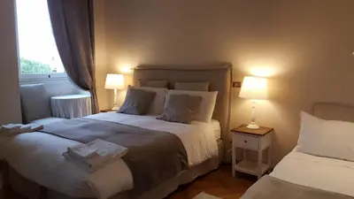 a bedroom with two beds and two lamps and a window at Bed & Breakfast A Casa di Lia a Roma in Rome