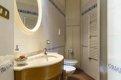 a bathroom with a sink and a toilet and a mirror at Lemon Tree Apartment Sistine Chapel in Rome