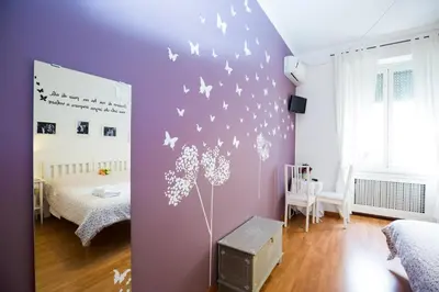 a bedroom with a purple wall with butterflies on it at I Prati Di Roma in Rome