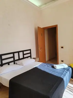 a bedroom with two beds and a door to a hallway at B&B Piazza Ragusa in Rome