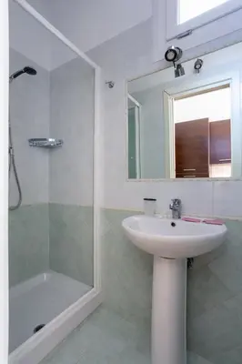 a bathroom with a sink and a shower and a mirror at Holiday rental St Peter's area in Rome
