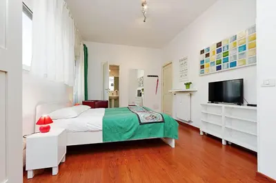 a white bedroom with a bed and a television at Holiday rental St Peter's area in Rome