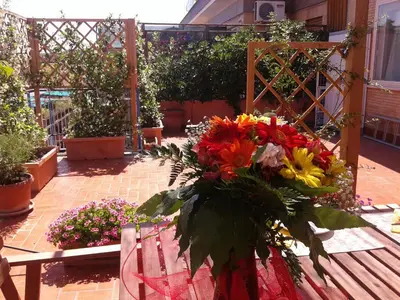 a bouquet of flowers on a table in a garden at Holiday rental St Peter's area in Rome