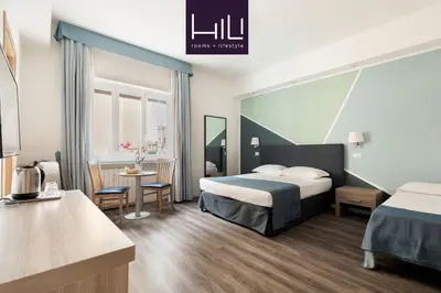 a hotel room with two beds and a table at Fleming Suites by Hili in Rome
