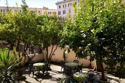 a courtyard with tables and chairs and trees at Alex Place in Rome